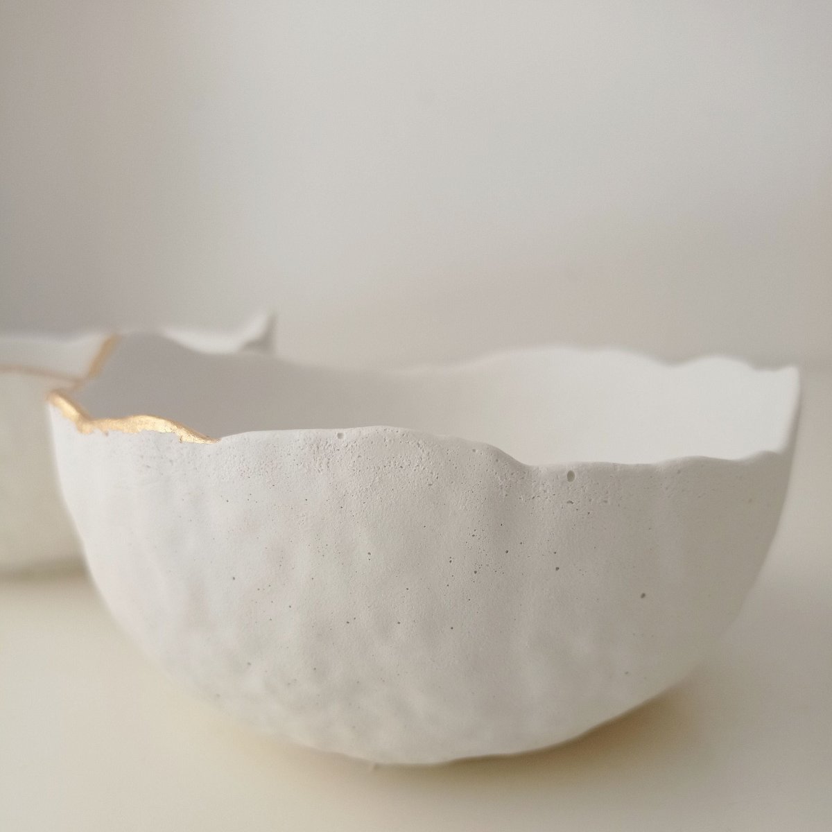 "Vide-poche en béton blanc et or"