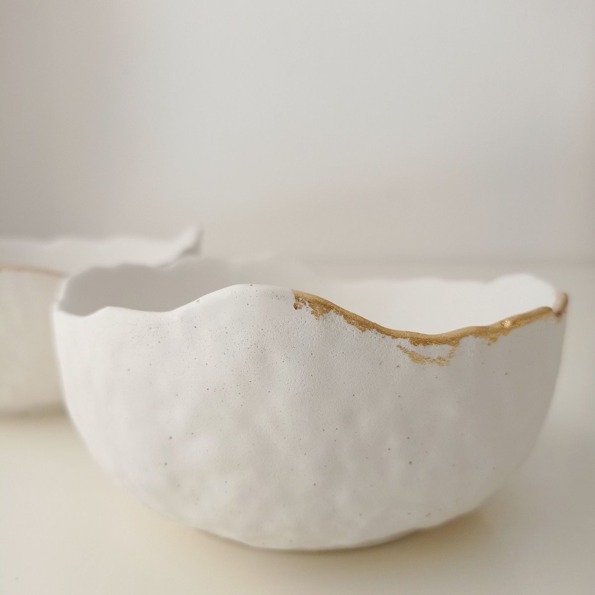 "vide-poches béton blanc et bordure or"