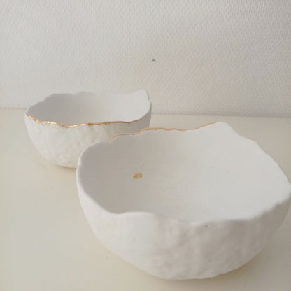 "Deux vide-poches en béton blanc avec or"