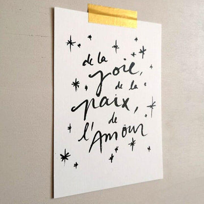 "Carte avec inscription De la joie, de la paix, de l'amour et des petites étoiles, accrochée avec un ruban doré"