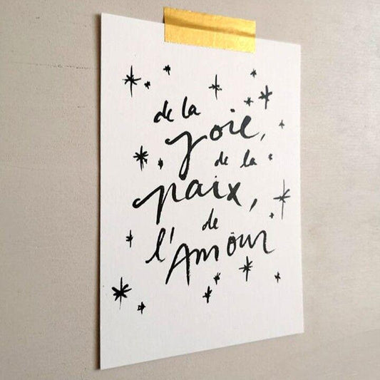 "Carte avec inscription De la joie, de la paix, de l'amour et des petites étoiles, accrochée avec un ruban doré"